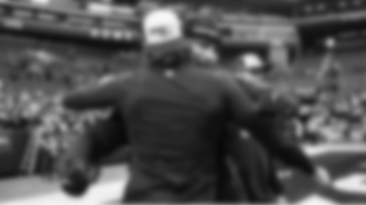 Tight end AJ Barner hugs a teammate on the field during pregame.