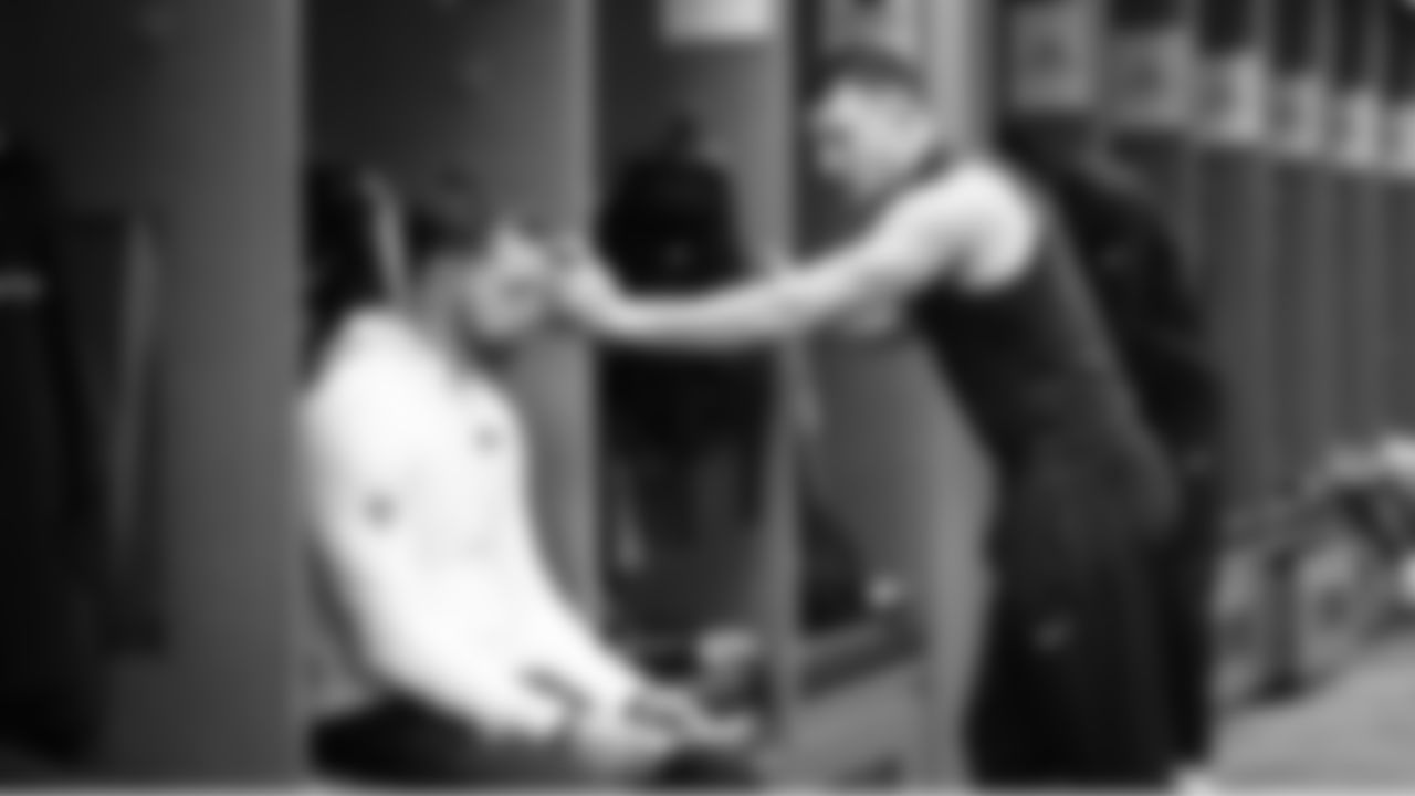 Safeties coach Jeff Howard confers with Ty Okada in the locker room before the game.