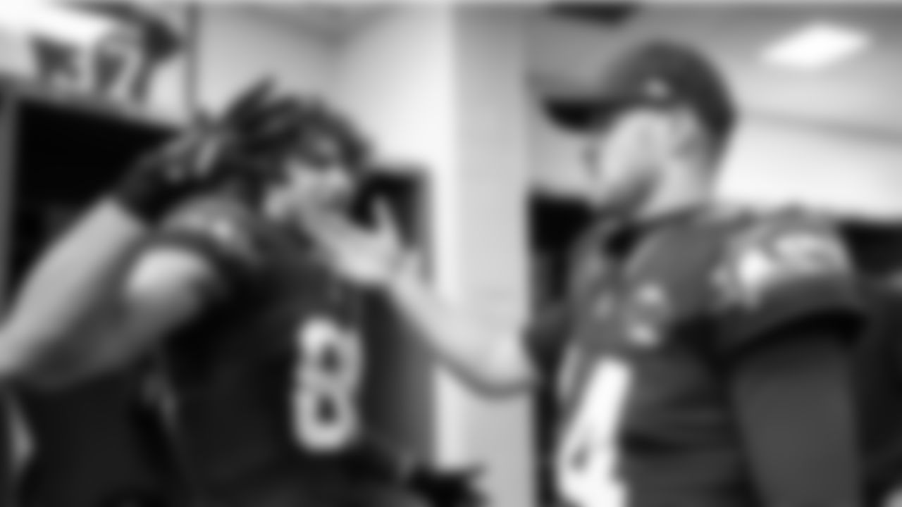 In the victorious locker room, AJ Barner congratulates quarterback Sam Darnold.