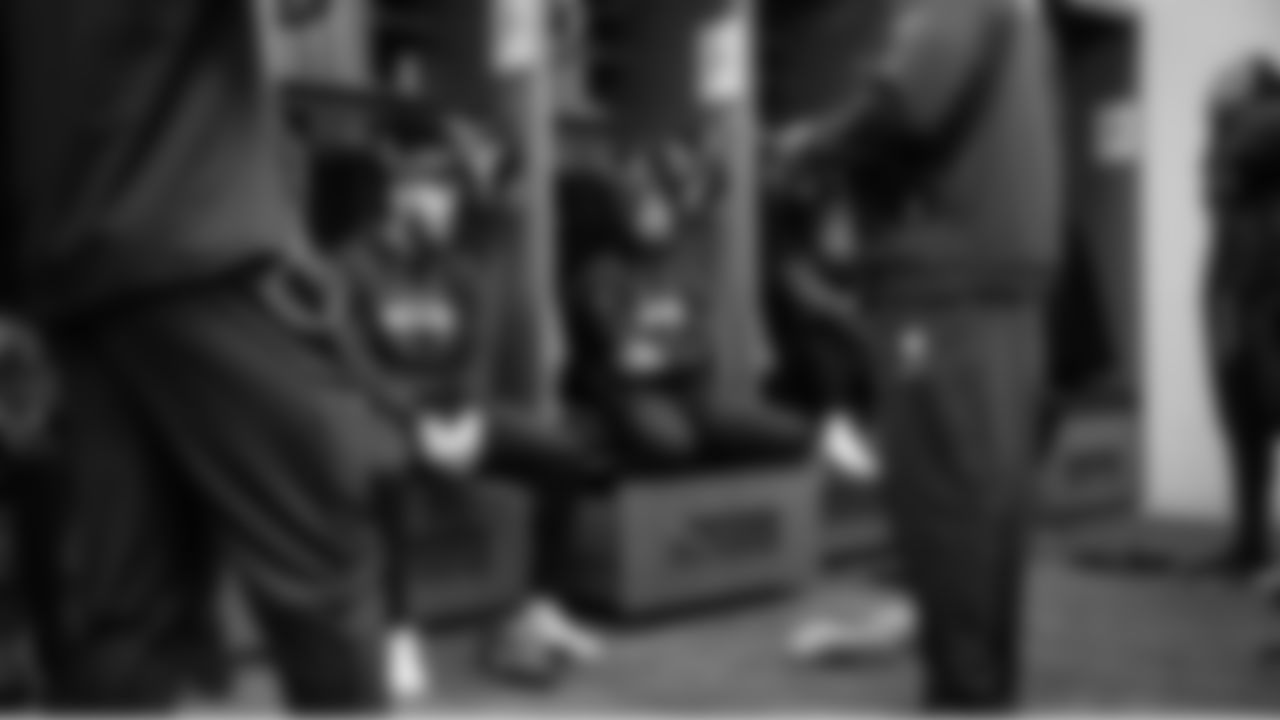 Receivers Jaxon Smith-Njigba, Cooper Kupp and Ricky White listen to receivers coach Frisman Jackson in the locker room before the game.