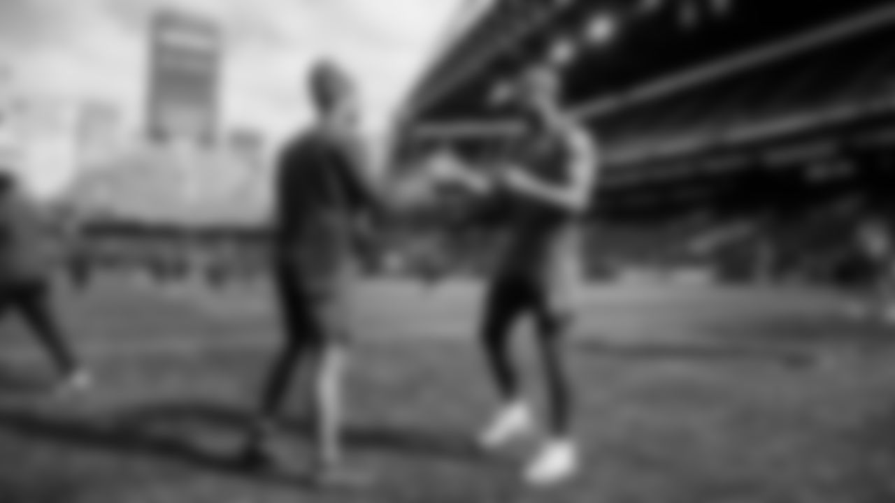 Receivers Jaxon Smith-Njigba and Cody White exchange handshakes on the field before the game.