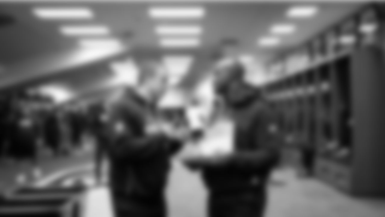 Assistant coach Jake Peetz confers with running back Kenneth Walker III in the pregame locker room.