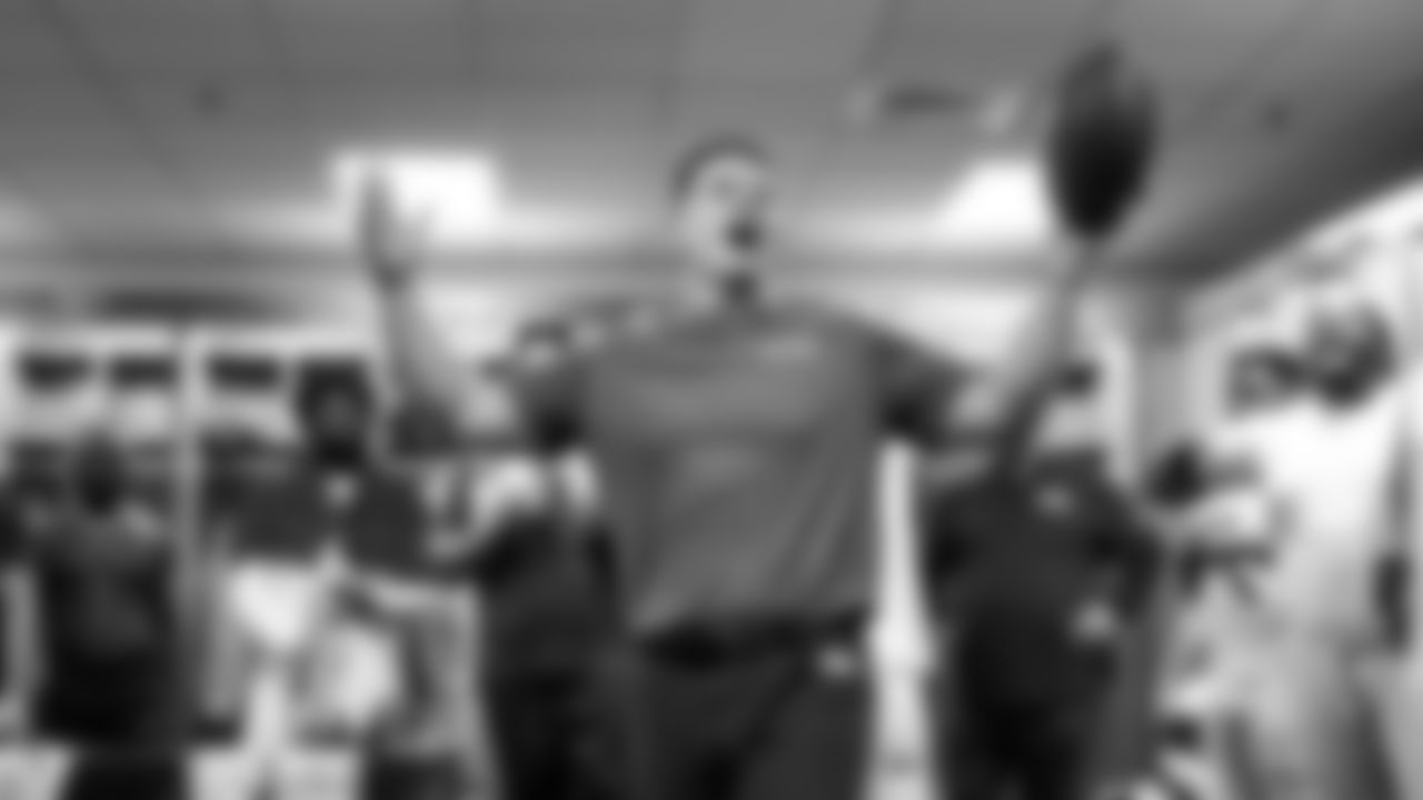 In the postgame locker room, head coach Mike Macdonald congratulates his team on another road victory.