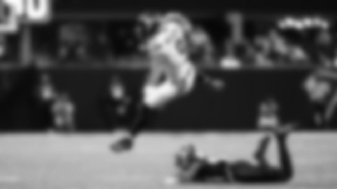 Seahawks running back Kenneth Walker III leaps over a Falcons defender.