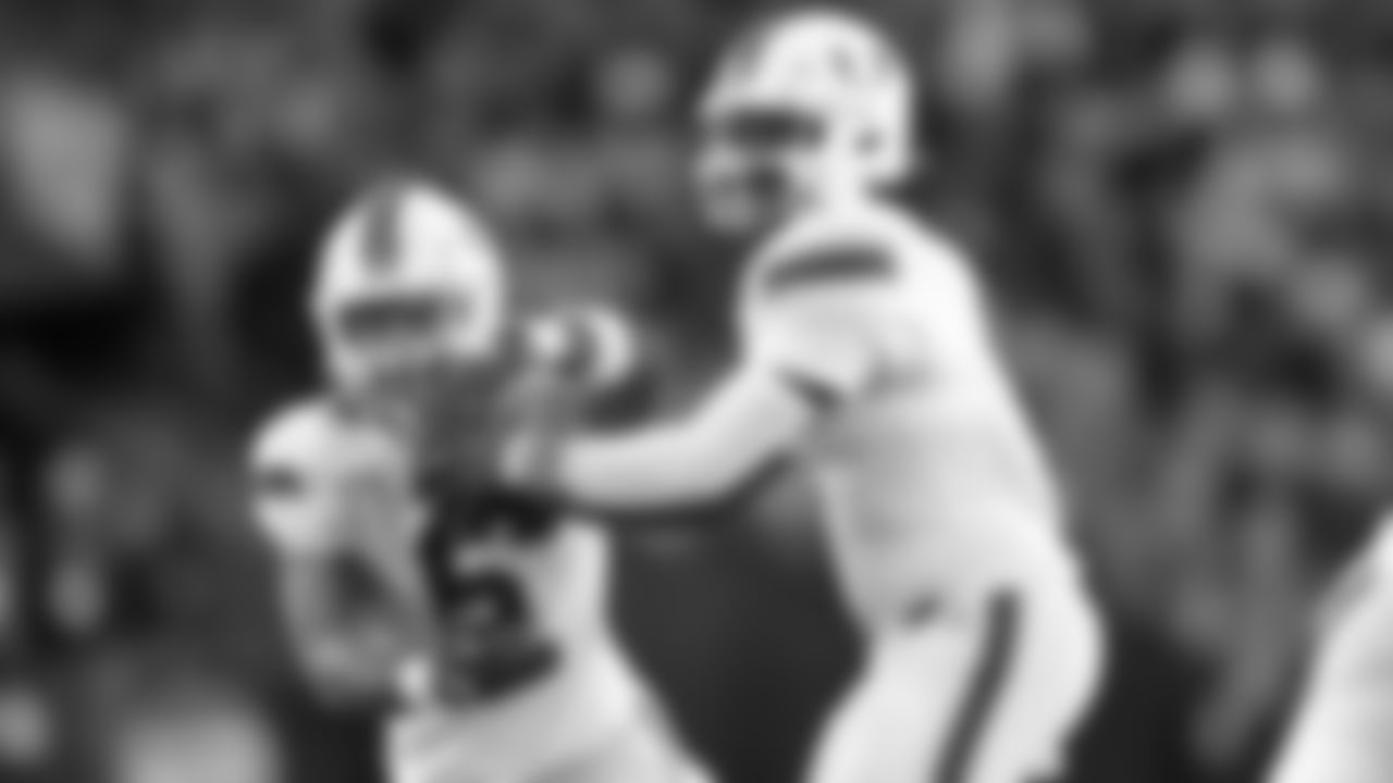 Miami quarterback Cam Ward, right, hands off to running back Damien Martinez during the first half of an NCAA college football game against Syracuse on Saturday, Nov. 30, 2024 in Syracuse, N.Y. (AP Photo/Adrian Kraus)
