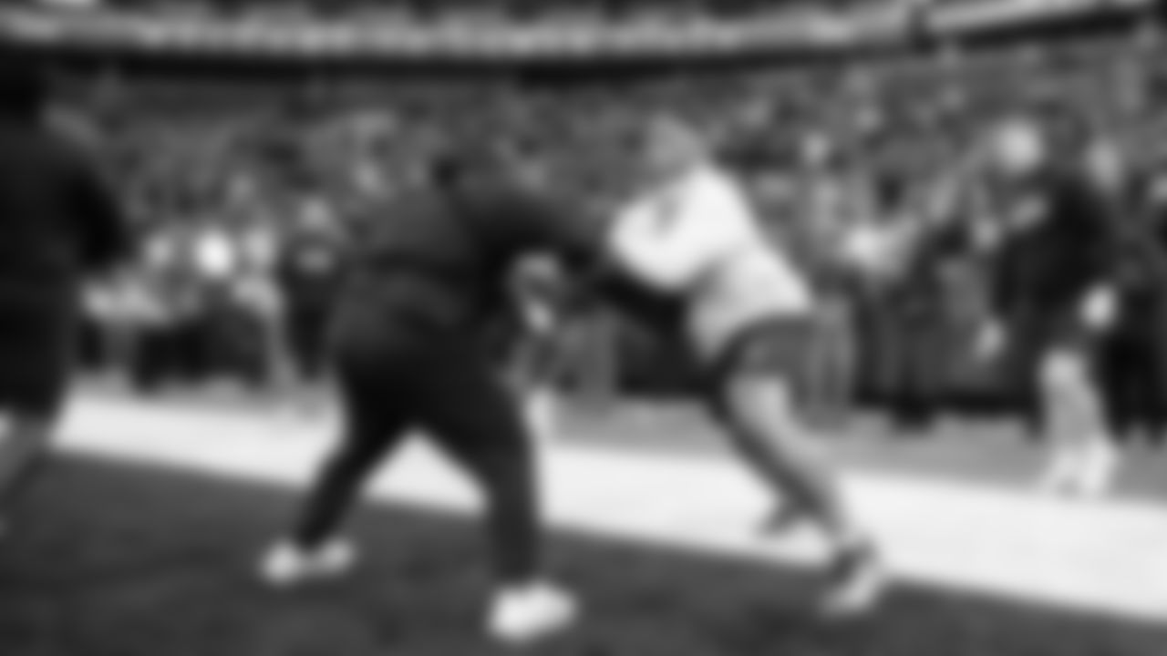 On the field, Byron Murphy II goes through early warmups in front of early-arriving fans.