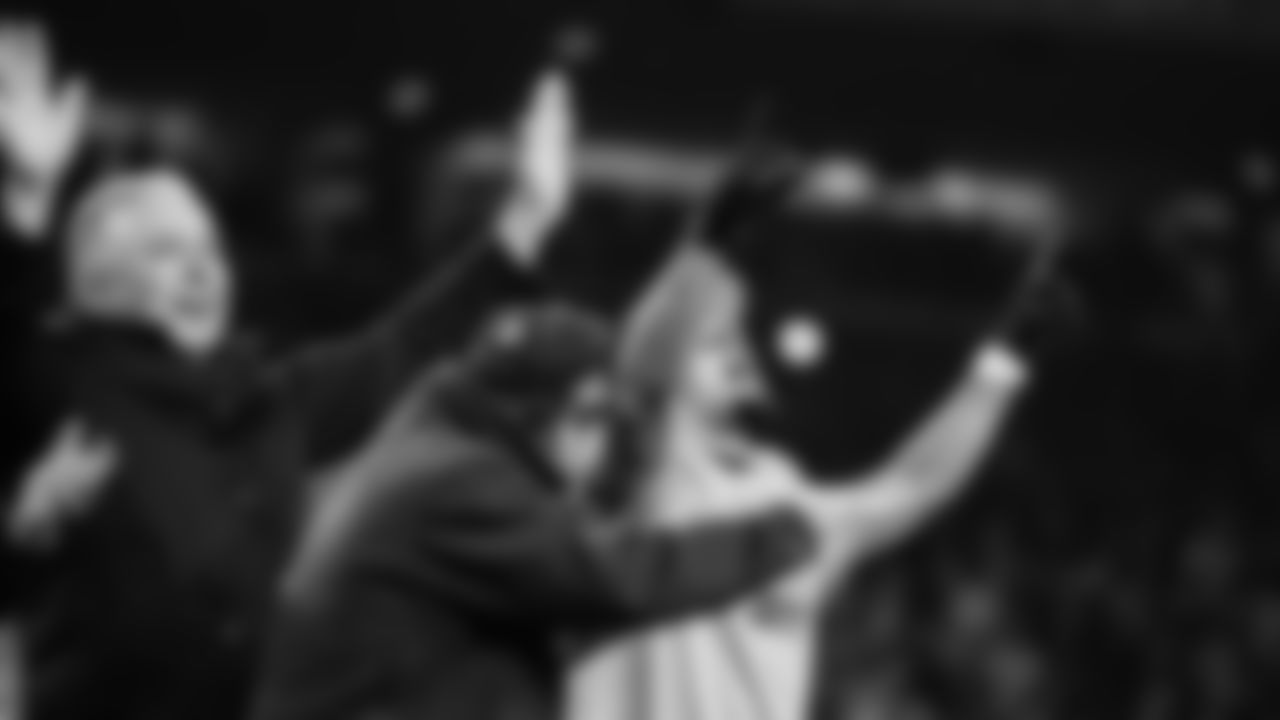 Seahawks receiver Jaxon Smith-Njigba, general manager John Schneider and team vice-chair Bert Kolde celebrate on the podium as the team is awarded the George Halas trophy for winning the NFC.