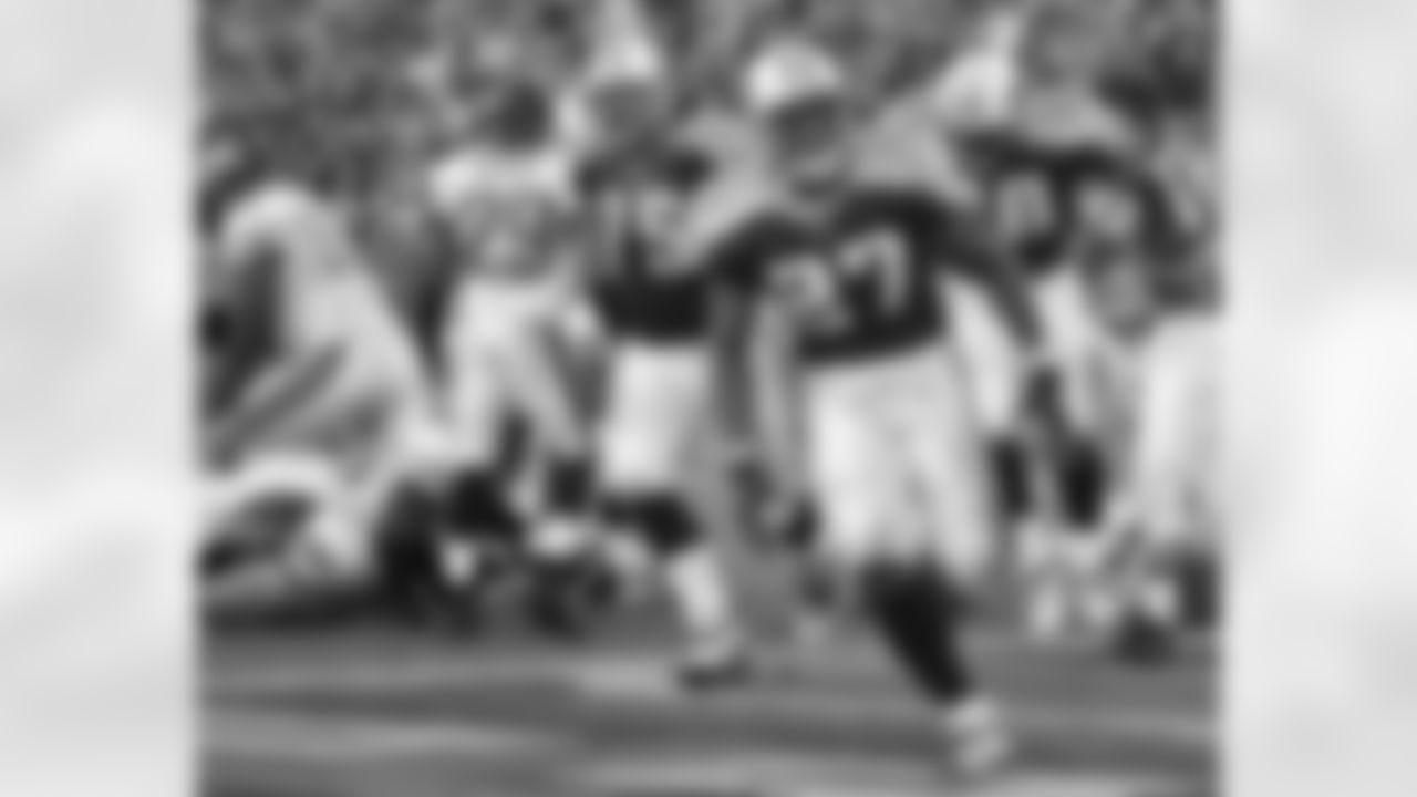 Tennessee Titans running back Eddie George (27) celebrates his 1-yard touchdown run in the fourth quarter against the Jacksonville Jaguars on Sunday, Oct. 13, 2002, in Nashville, Tenn. George rushed for 113 yards and scored one touchdown running and one touchdown on a pass reception. Behind George are Jaguars cornerback Jason Craft (29) and Titans guard Benji Olson (75) and running back Mike Green (20). The Titans won 23-14. (AP Photo/John Russell)