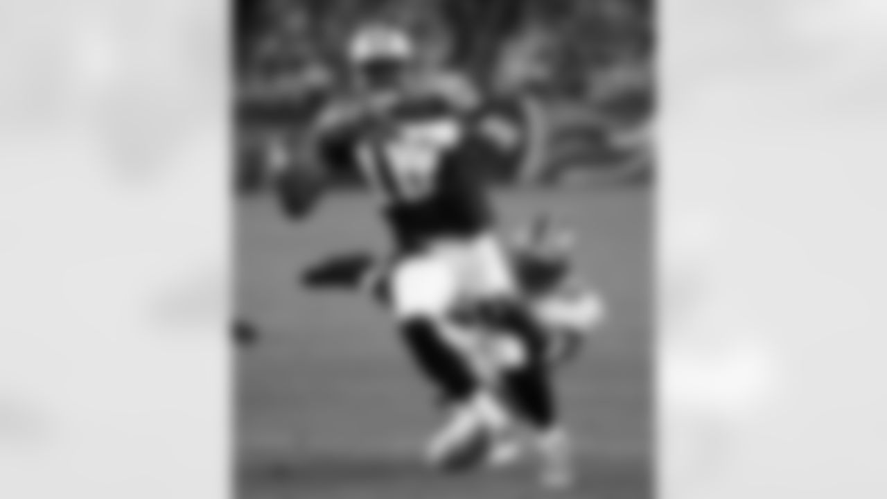 Tennessee Titans rookie quarterback Vince Young (10) is pressured by New Orleans Saints defensive end Tommy Davis (96) in the fourth quarter of their pre-season football game in Nashville, Tenn., on Saturday, Aug. 12, 2006. The Saints defeated the Titans, 19-16. (AP Photo/John Russell)