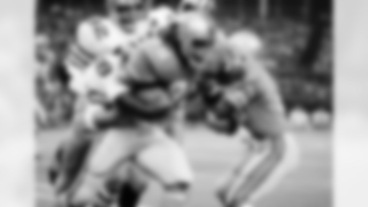 Houston Oilers running back Woody Campbell (35) has the Saints hanging onto him as he went around his right end to pick up ten yards in the first quarter at the Houston Astrodome, Oct. 3, 1971, Houston, Tex. Putting the hanging stop to Campbell are New Orleans Saints Hugo Hollas (18), Bob Pollard (82) along with an unidentified Saint. The game ended in a 13-13 tie. (AP Photo/Ed Kolenovsky)