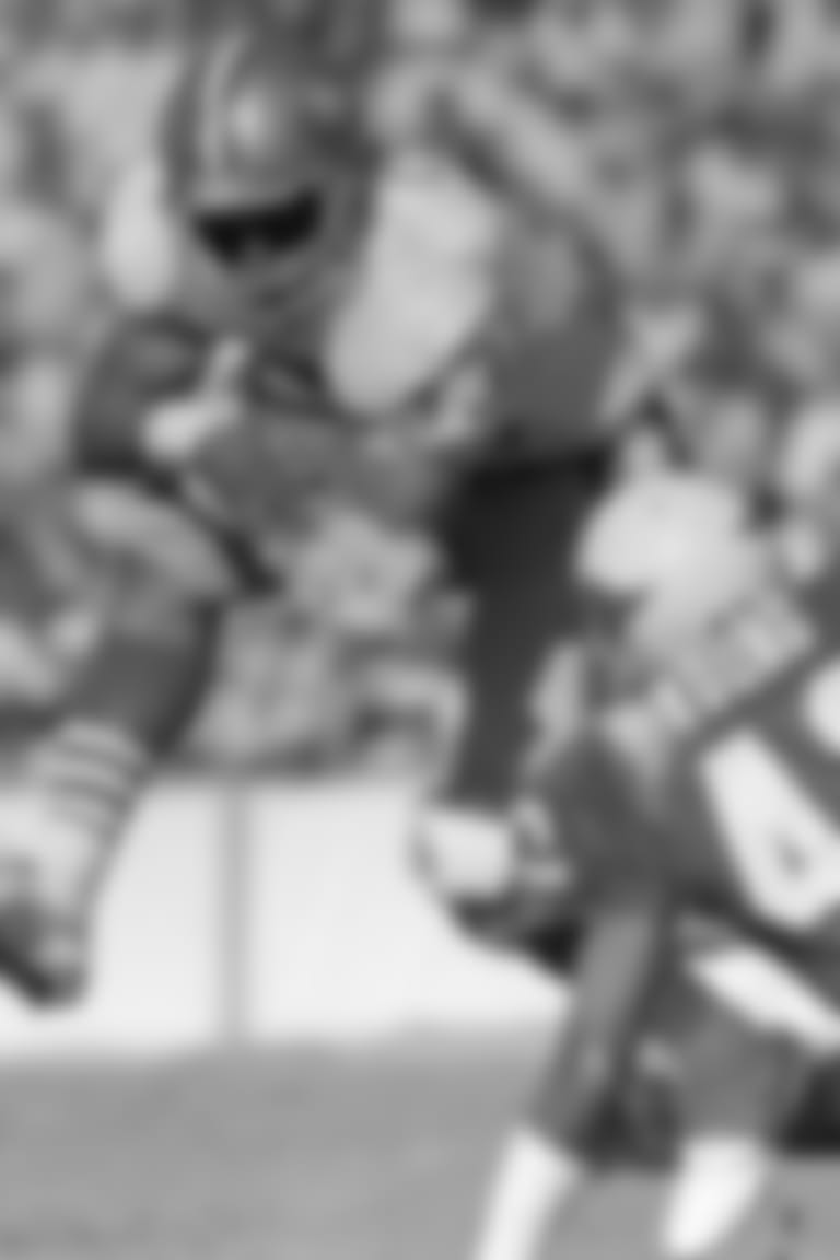 San Francisco 49ers Roger Craig takes to the air to try to pick up extra yardage as Phoenix Cardinals Lonnie Young moves in for the tackle during first quarter action in their game on Sunday, Nov. 6, 1988 in Tempe, Arizona. San Francisco led 16-0 at the half. (AP Photo/Paul Sakuma)